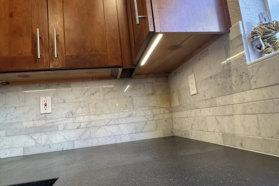 Linear LED under-cabinet lighting over a marble backsplash in a Sonoma County kitchen